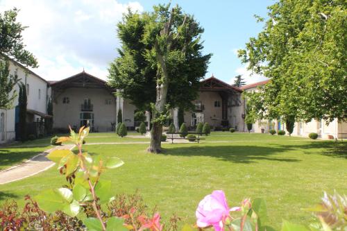 a house with a yard with a tree and flowers at Domaine des Chais in Thénac