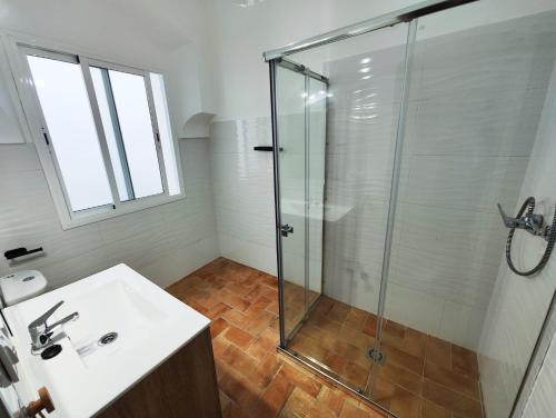 uma casa de banho com uma cabina de duche em vidro e um lavatório. em Casa SANTA MARÍA em Carmona