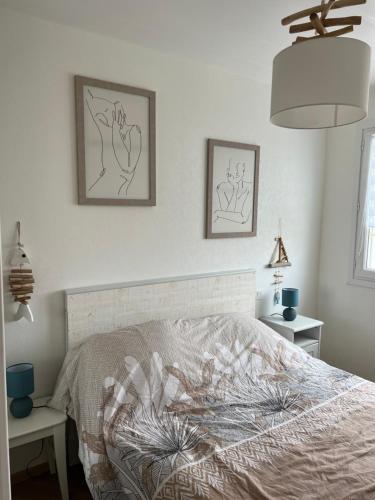 une chambre avec un lit et deux tableaux au mur dans l'établissement montsetmerveillesvuemer, à Notre-Dame-de-Monts