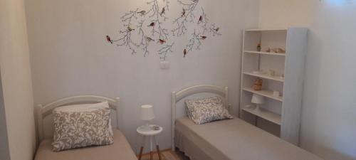 - une chambre avec 2 lits et un lustre sur le mur dans l'établissement Casa Deborah, à Ripenda Kras