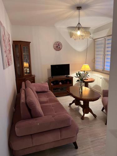 uma sala de estar com um sofá e uma mesa em Apartman Krasota em Banja Luka