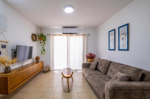 a living room with a couch and a tv at רז אירוח ברמה- in Qasrîne