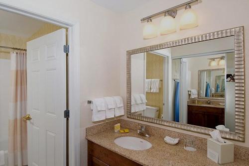 baño con lavabo y espejo grande en Residence Inn by Marriott Saratoga Springs, en Saratoga Springs