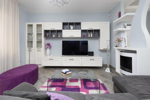 a living room with a purple couch and a tv at Partenope in Sorrento Coast in Piano di Sorrento