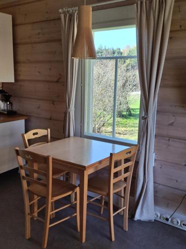 uma mesa de jantar com cadeiras e uma janela em Norrby Gård - Piian kamari em Raseborg