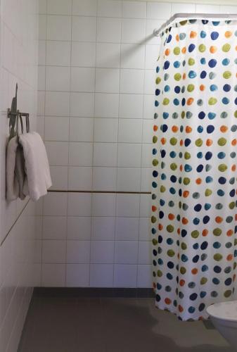 uma casa de banho com uma cortina de chuveiro com bolinhas em Norrby Gård - Piian kamari em Raseborg