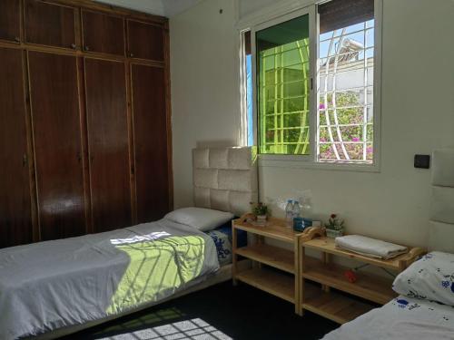 - une chambre avec 2 lits jumeaux et une fenêtre dans l'établissement MOHAMMED AIRPORT LUXURY VILLA, à Deroua