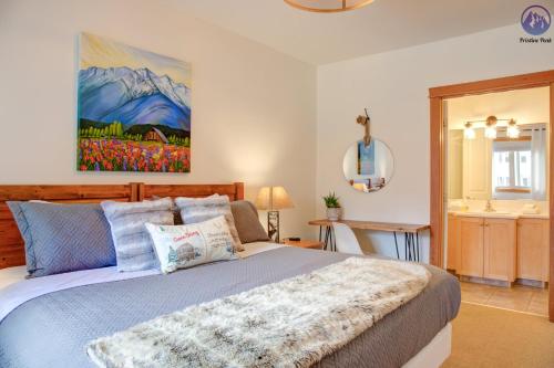 a bedroom with a bed and a painting on the wall at Modern Nordic 2 Bedroom Mountain View Condo in Canmore