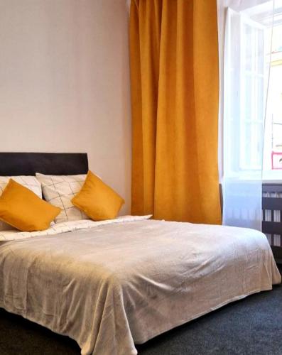 a bed with two yellow pillows and a window at Prywatny pokój w centrum miasta Pokój nr 3 in Warsaw