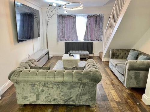 a living room with a couch and a table at Spacious 4 bedroom house in Billericay