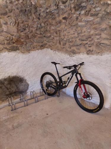 una bicicletta è parcheggiata accanto a un muro di pietra di Appartamenti il bersaio Alloggio 3 a Sambuco