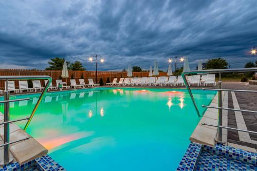 a swimming pool with chairs and a cloudy sky at Sofion hotel&resort in Solotvyno