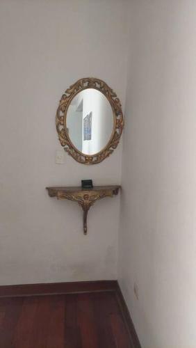 La Molina的住宿－Elegante La Molina，一面白色墙壁上的镜子,一面有木架