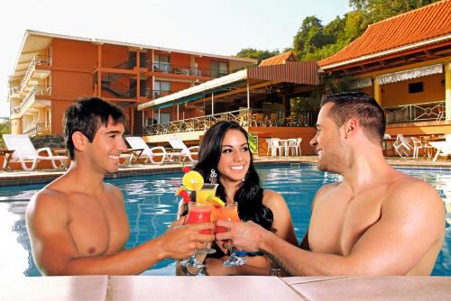 a group of three people sitting in the pool with drinks at The Beach House in Panama City