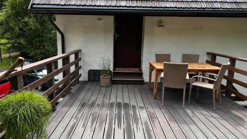 een houten terras met een tafel en stoelen erop bij Apartamenty 3 Pory Roku Lato in Komarno