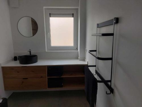 a bathroom with a mirror and a dresser and a window at Gite Comme chez soi in Spa