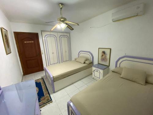 a bedroom with two beds and a ceiling fan at Marina 4 in Safaga