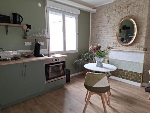 uma cozinha com uma mesa e uma bancada em L'Escapade Inattendue em Calais