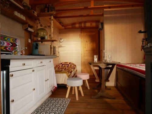 - une cuisine avec une table et un lit dans une chambre dans l'établissement Les roulottes de Moulin Rouge, à Audelange