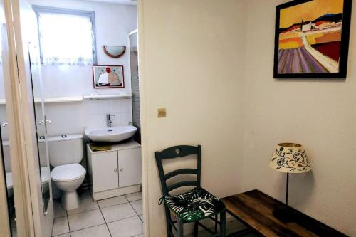 La salle de bains est pourvue de toilettes, d'un lavabo et d'une chaise. dans l'établissement Le Dali, Plage à 5 min parking, à La Seyne-sur-Mer