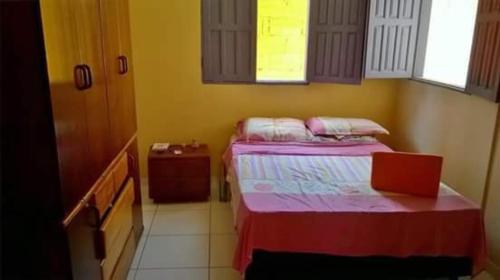 a small room with two beds and a window at Casinha Temporada Itaúnas in Itaúnas