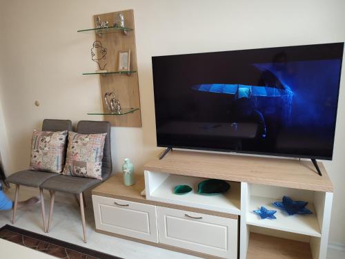 TV de pantalla plana con silla en Кай Apartment's Sarafovo en Burgas