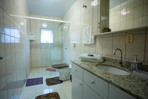uma casa de banho com um lavatório, um WC e um chuveiro em Lar do Vale - Vinhedos em Bento Gonçalves