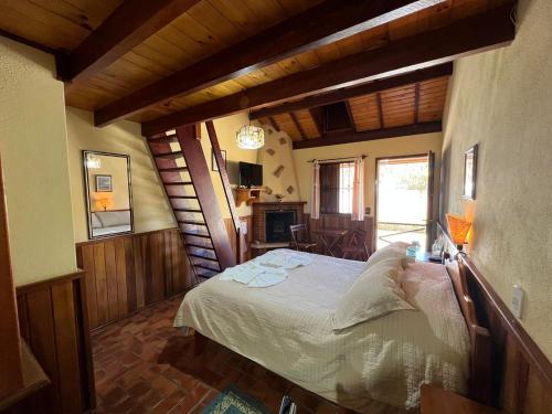 ein Schlafzimmer mit einem großen Bett in einem Zimmer in der Unterkunft Banyvas Chalés in Monte Verde