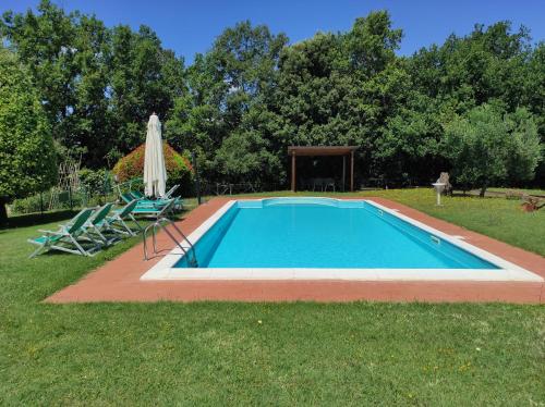 una piscina con 2 sillas y una sombrilla en Il Colombaiolo en Castelmuzio