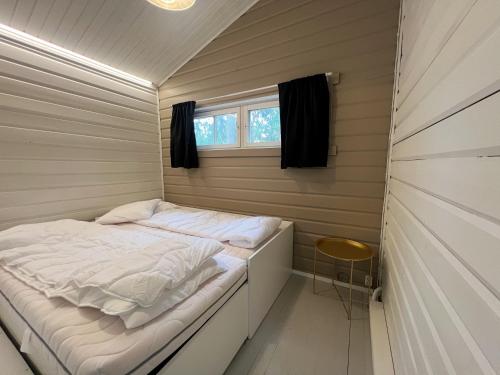 a bed in a small room with a window at Lake Cottage with sauna (near City) in Jyväskylä