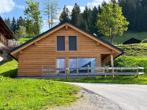 een houten huis op een heuvel naast een weg bij Panoramagasthof Kristberg in Silbertal
