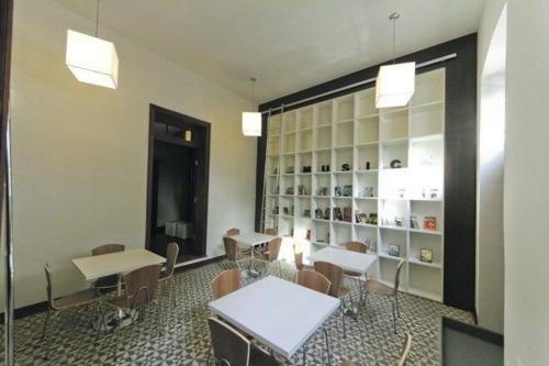 a room with tables and chairs and a book shelf at Apto 1Q 300MB Fibra Ótica Próx Shop Estação in Curitiba