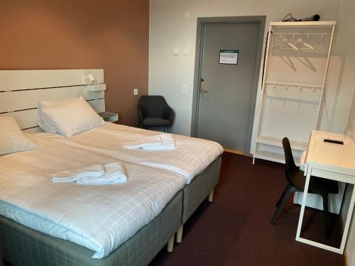 a hotel room with a bed and a desk and chair at Ahlgrens Hotell Bed & Breakfast in Gävle