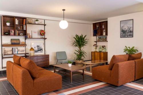 a living room with two chairs and a table at Best Western Plus Hotel Cargo in Dunkerque