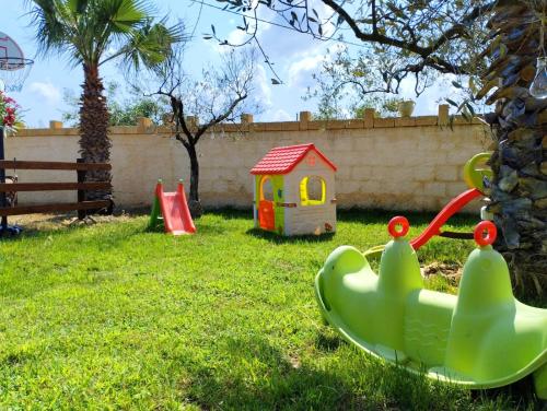 einen Kinderspielplatz mit einem Spielzeugboot und einem Haus in der Unterkunft Casa Vacanze 'Al Giardino degli Ulivi' in Marinella di Selinunte