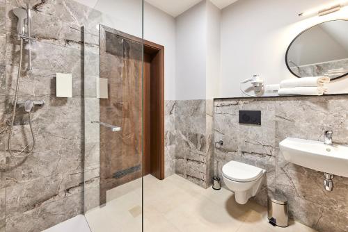 W łazience znajduje się prysznic, toaleta i umywalka. w obiekcie Kyriad KARKONOSZE w mieście Wojcieszyce