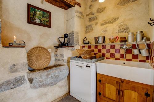- une cuisine avec un évier et un comptoir dans l'établissement Gite Chez Maria avec piscine nage a contre courant, à Toulonjac