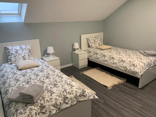 een slaapkamer met 2 bedden en 2 nachtkastjes bij Coquet appartement aux pieds des montagnes in Scionzier
