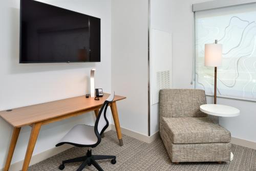 a room with a desk and a chair and a television at Element Kansas City Overland Park in Leawood