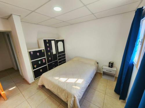 a small bedroom with a bed and a dresser at Departamento Viajeros Ruta 6 in General Roca