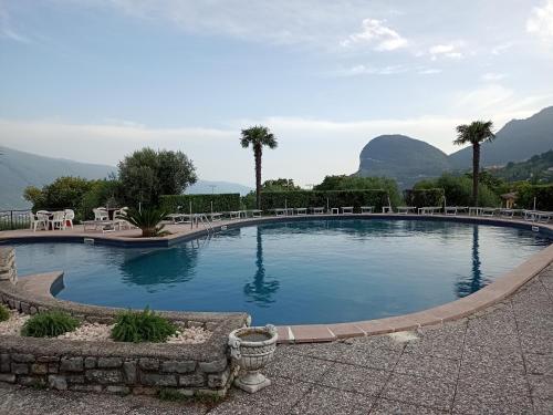 a large swimming pool with mountains in the background at appartamenti Residenza 1928 in Tremosine Sul Garda