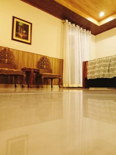 a living room with a white tile floor and chairs at Panorama Luxury House in Nathia Gali