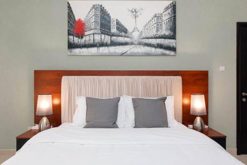 ein Schlafzimmer mit einem großen weißen Bett mit zwei Lampen in der Unterkunft Urban Caves - Chic Apartment With Balcony Near The Walk JBR in Dubai