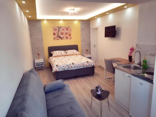 a bedroom with a bed and a kitchen with a couch at Cozy apartment close to Dubrovnik in Neum