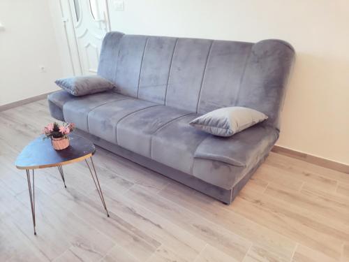 un sofá gris en una sala de estar con mesa en Cozy apartment close to Dubrovnik en Neum