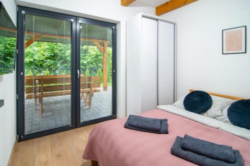 a bedroom with a bed and a sliding glass door at Domki na odludziu in Kazimierz Dolny