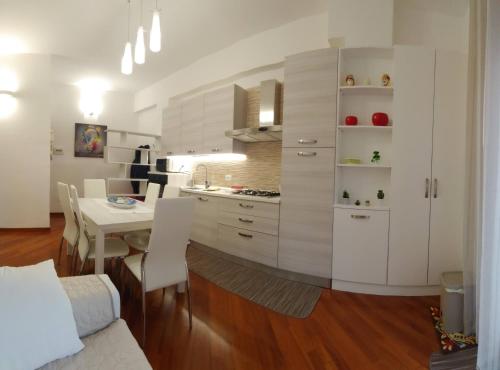 a kitchen with white cabinets and a table with chairs at Max's Apartment in Palermo