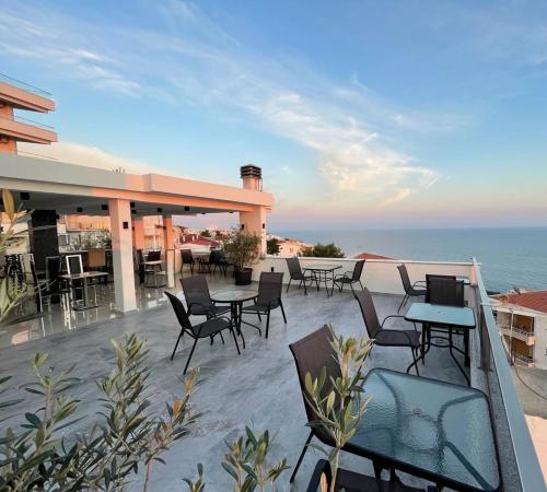 eine Terrasse mit Tischen und Stühlen auf einem Gebäude in der Unterkunft Molla Apartments in Ulcinj