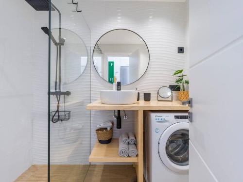 a bathroom with a washing machine and a mirror at Apartamento Dara - Apartamento con piscina in Tías