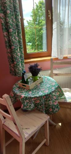 un tavolo con una bottiglia di vino e una sedia di Gandelinka Park Kędrzyno 